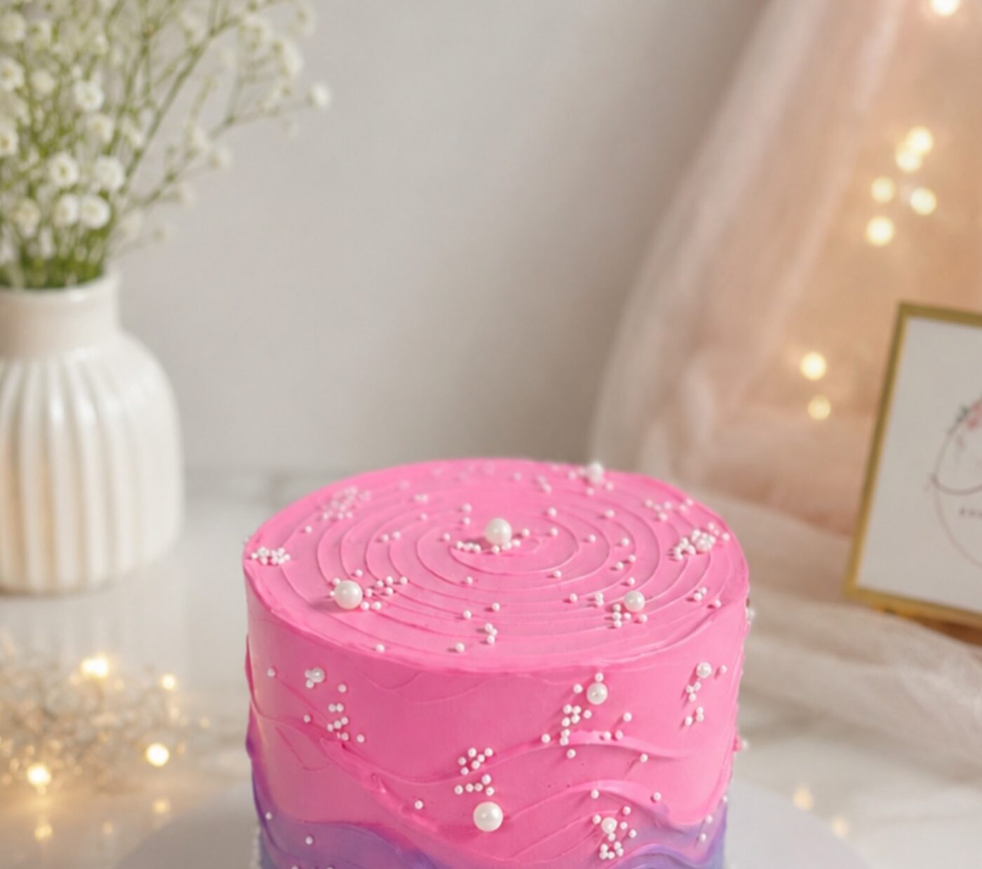 Pink and purple swirled birthday cake with pearls